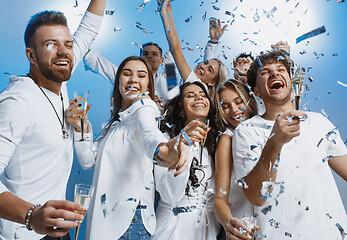 Image showing Group of cheerful joyful young people standing and celebrating together over blue background