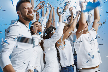 Image showing Group of cheerful joyful young people standing and celebrating together over blue background