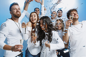 Image showing Group of cheerful joyful young people standing and celebrating together over blue background