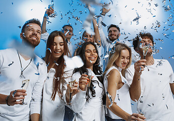 Image showing Group of cheerful joyful young people standing and celebrating together over blue background