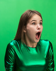 Image showing The woman screaming with open mouth isolated on green background, concept face emotion