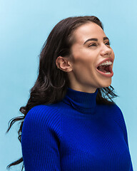 Image showing The woman screaming with open mouth isolated on blue background, concept face emotion