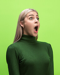 Image showing The woman screaming with open mouth isolated on green background, concept face emotion