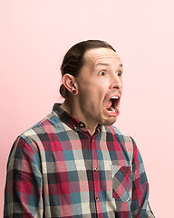 Image showing The man screaming with open mouth isolated on pink background, concept face emotion