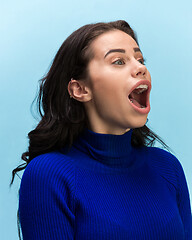 Image showing The woman screaming with open mouth isolated on blue background, concept face emotion