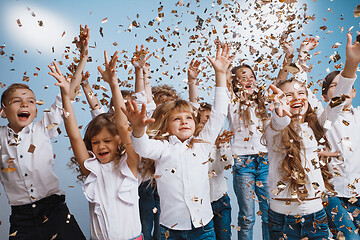 Image showing Adorable kids have fun together, throw colourful confetti,