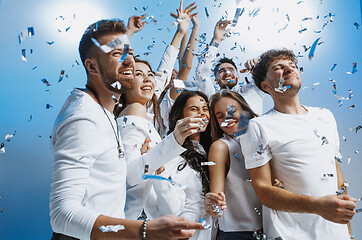 Image showing Group of cheerful joyful young people standing and celebrating together over blue background