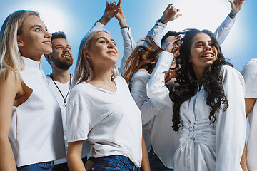 Image showing Group of cheerful joyful young people standing and celebrating together over blue background