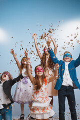 Image showing Adorable kids have fun together, throw colourful confetti,