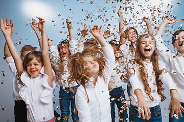 Image showing Adorable kids have fun together, throw colourful confetti,