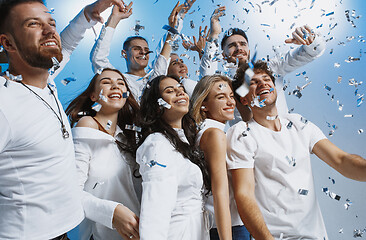 Image showing Group of cheerful joyful young people standing and celebrating together over blue background