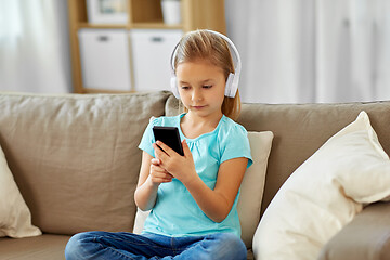 Image showing girl in headphones listening to music at home