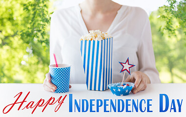 Image showing woman eating popcorn with drink and candies