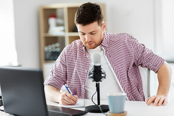 Image showing audio blogger with laptop, microphone and notebook