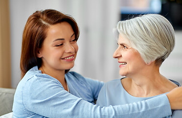 Image showing senior mother with adult daughter hugging at home