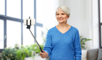 Image showing smiling senior woman taking selfie by smartphone