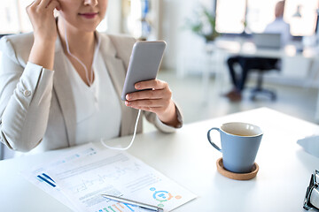 Image showing businesswoman with earphones and smartphone