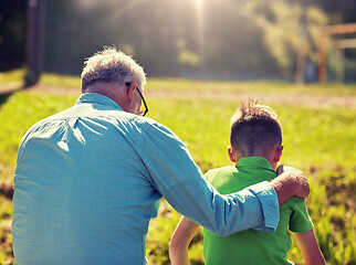 Image showing grandfather and grandson hugging outdoors