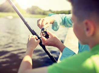 Image showing boy and grandfather with fishing rod on river