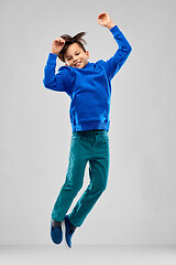 Image showing portrait of smiling boy in blue hoodie jumping