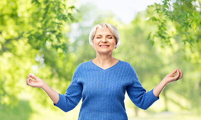 Image showing smiling senior woman in blue sweater chilling