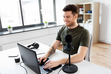 Image showing man with laptop and microphone at home office