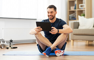 Image showing man with tablet computer on exercise mat at home