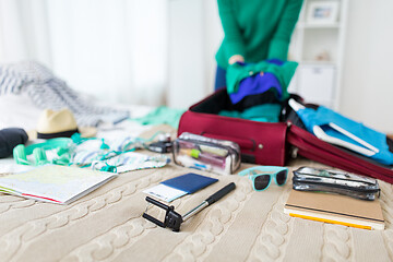 Image showing woman packing travel bag at home or hotel room