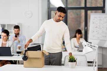 Image showing sad fired office worker packing personal stuff