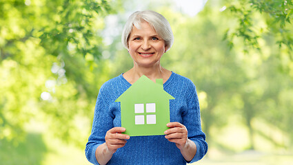 Image showing smiling senior woman holding green house icon