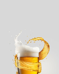 Image showing Refreshing beer glass with splash and thick foam.