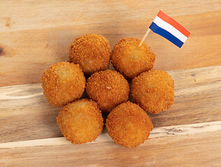 Image showing Dutch traditional snack bitterbal on a serving board, dutch flag