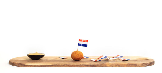 Image showing Dutch traditional snack bitterbal, just one left on a wooden ser