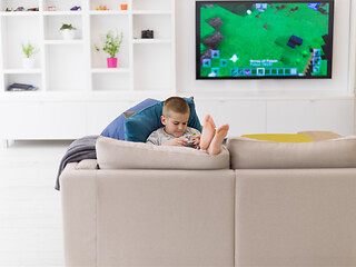 Image showing little boy playing games on smartphone