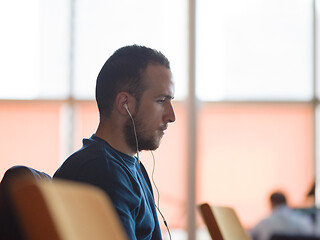 Image showing business man listening music on headphones