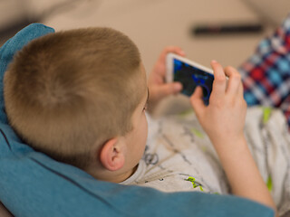 Image showing little boy playing games on smartphone