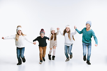 Image showing Group of kids in bright winter clothes, isolated on white