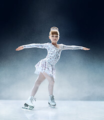 Image showing Little girl figure skating at the indoor ice arena.