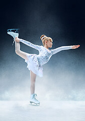 Image showing Little girl figure skating at the indoor ice arena.