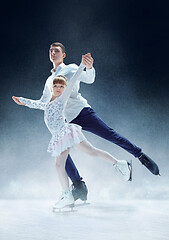 Image showing Little girl figure skating at the indoor ice arena.