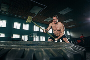 Image showing Shirtless man flipping heavy tire at gym