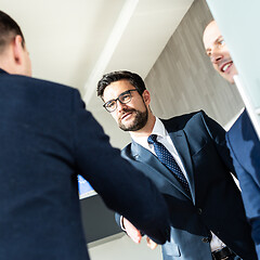 Image showing Group of confident business people greeting with a handshake at business meeting in modern office or closing the deal agreement by shaking hands.