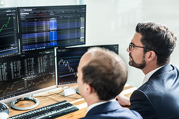 Image showing Stock brokers looking at computer screens, trading online.