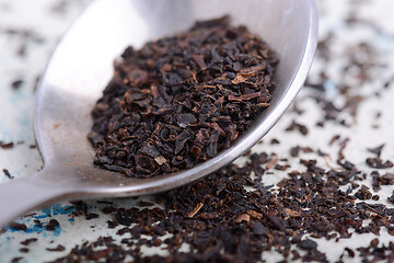 Image showing Black tea in a spoon on a white background. Close up shot