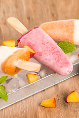 Image showing Homemade raspberries and peach popsicles