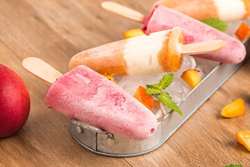 Image showing Homemade raspberries and peach popsicles