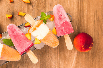 Image showing Homemade raspberries and peach popsicles