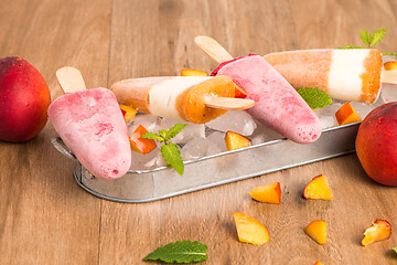 Image showing Homemade raspberries and peach popsicles