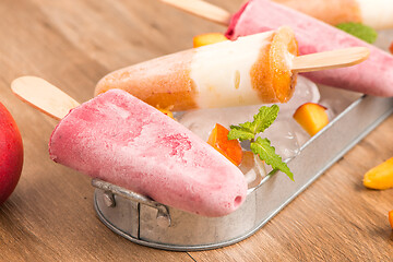 Image showing Homemade raspberries and peach popsicles