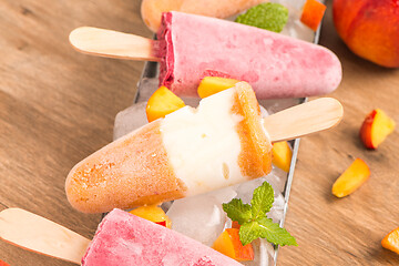 Image showing Homemade raspberries and peach popsicles